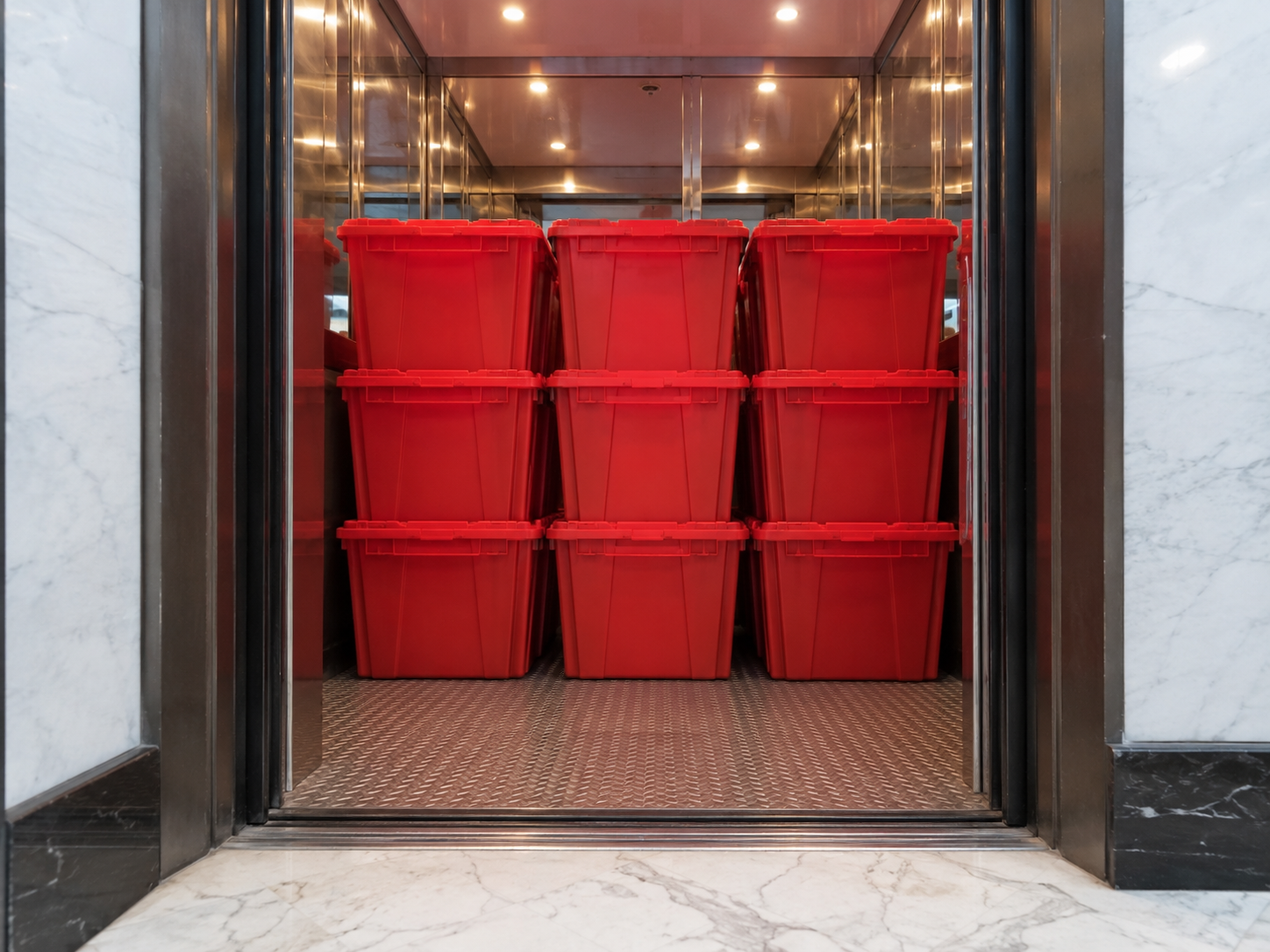 EazyCrate red moving bins loaded into Manhattan apartment building freight elevator — fits standard NYC elevator dimensions for doorman and pre-war buildings